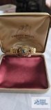 Gold colored sweetheart bracelet with blue stone, marked Carmen, The DFB Co.