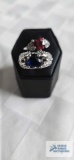2 silver colored rings, one blue heart gemstone and 1 red heart gemstone, no markings found