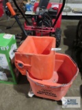 Orange commercial mop bucket, made by White