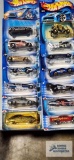 Fourteen 2004 Roll Patrol Hot Wheels cars, new in packages.