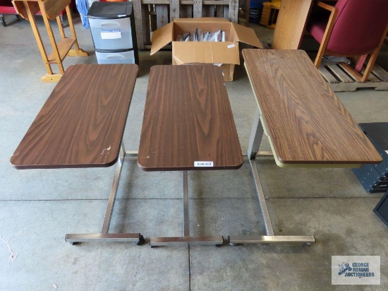 Three roll about adjustable height over bed tables