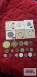 Variety of foreign coins, some in coin holders.