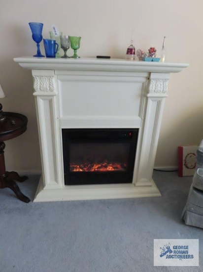 Painted white electric fireplace. Front of fireplace has damage in two spots.