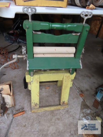 Green and yellow painted antique clothing wringer on homemade stand made by Anchor Brand