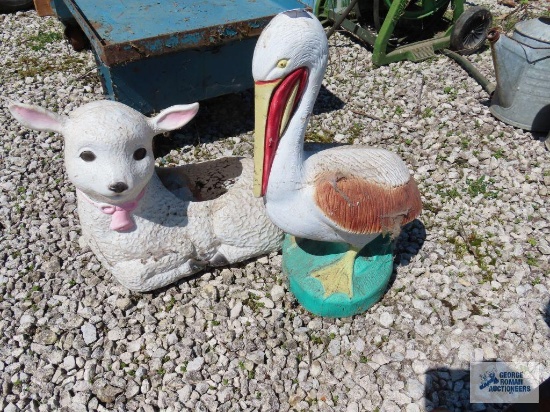 Concrete pelican yard decoration and plastic lamb planter