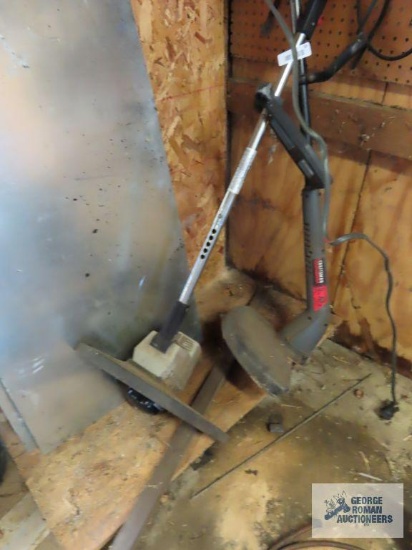 Electric weed eaters and tools on wall