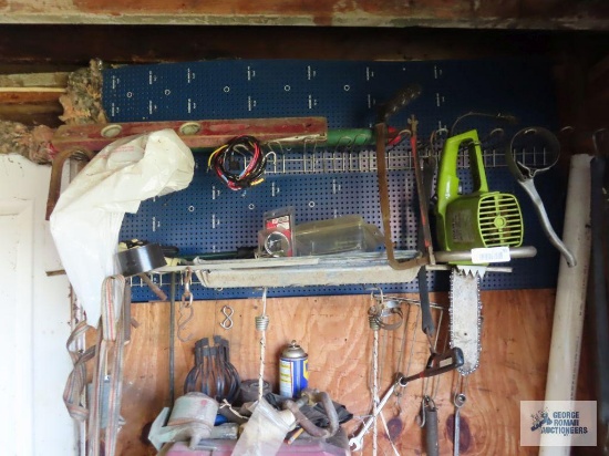 Electric chainsaw, assorted wrenches and other tools including items on floor in corner