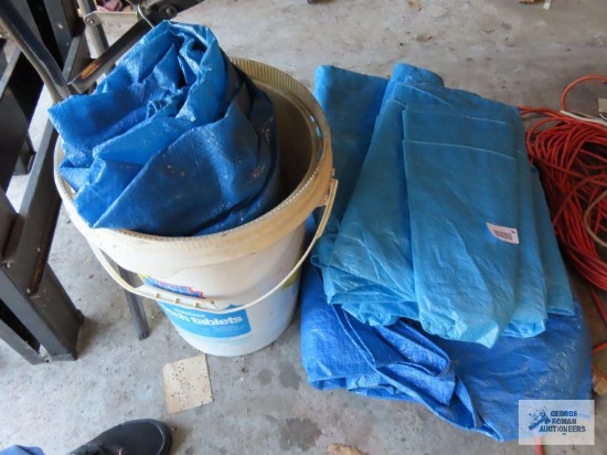 Three blue tarps and bucket
