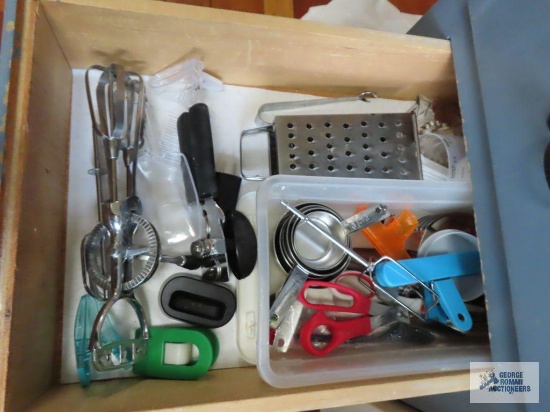 Dish towels and hot pads and assorted kitchen utensils in two drawers