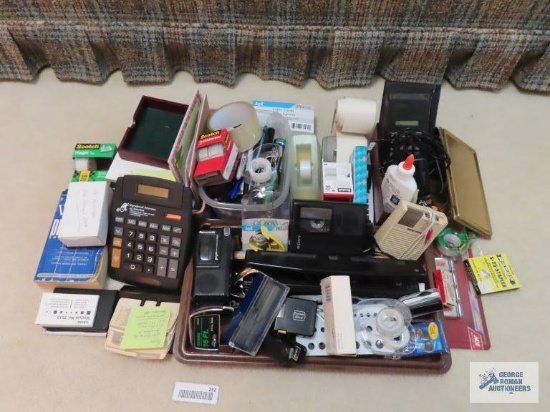 Desktop items, including stapler. Tape holders. Tape. Pens and pencils. Calculators.