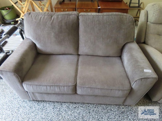 Ashley Furniture gray loveseat in garage.