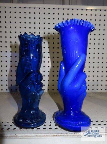 Two blue glass hand held vases