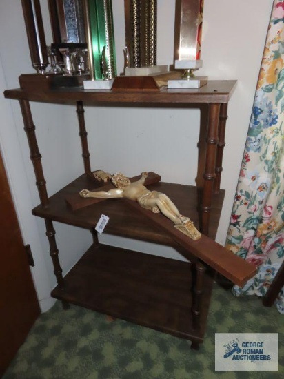 Three tiered shelf and religious wall hanging