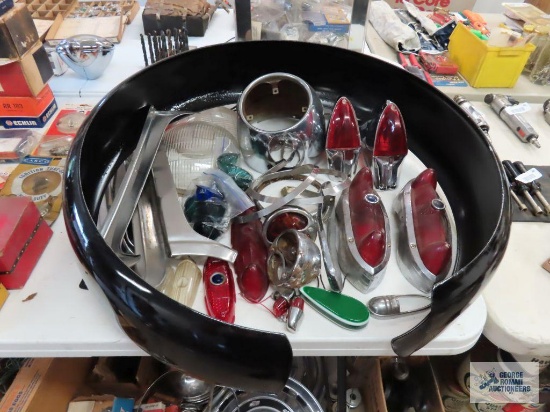 Assorted used automotive parts including tail lights, glass headlights, and spare tire cover