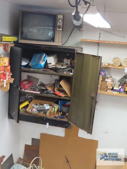 Hardware, automotive parts, and automotive body tools in cabinet and on floor in front of cabinet