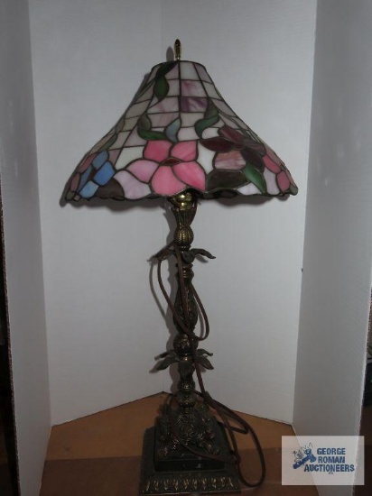 Metal based lamp with floral plastic shade, lamp is approximately 28", shade is 9"x 14".
