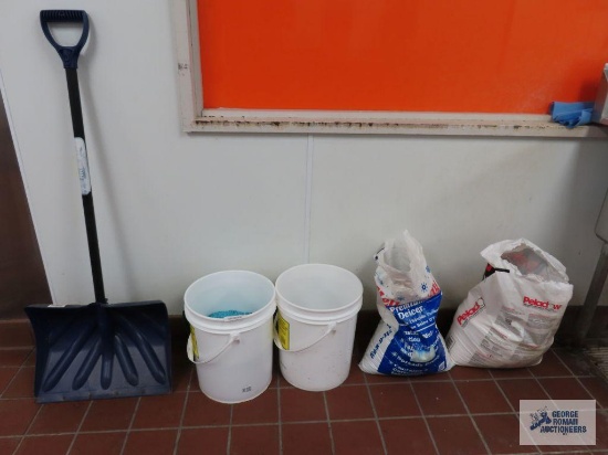 Rock salt, snow shovel, and buckets with lids
