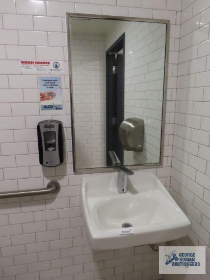 Bathroom sink with hanging mirror, soap dispenser, tissue paper dispenser, napkin dispenser, and