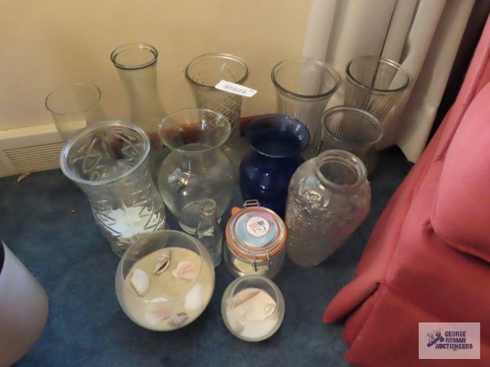 Variety of vases and glass fishbowl with sand and seashell decorations
