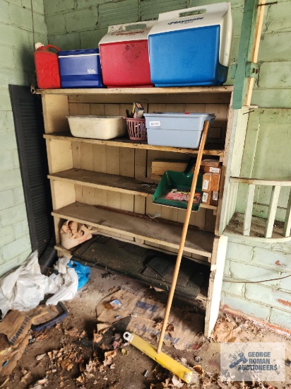 Assorted coolers hardware and etc on wood shelving.
