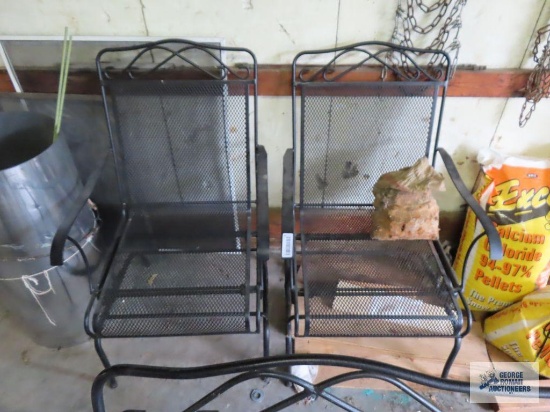 Wrought iron outdoor glider and two spring chairs.