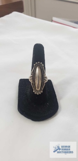 Sterling silver ring with elongated smooth oval center framed by delicate beaded and rope twist