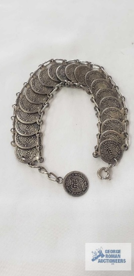 Silver colored metal souvenir bracelet with an articulated chain of interlocking replica coin