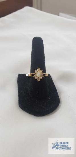 Gold-plated cocktail ring with a marquise cut white opal center surrounded by a sparkling halo of