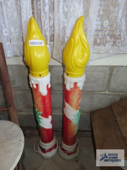 Two lighted, weighted, outdoor plastic candle decorations. 38".