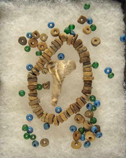 Group of assorted drilled stone and trade beads along with a 1 3/16" flint drill found together at a