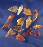 Set of 14 assorted arrowheads made from colorful material.