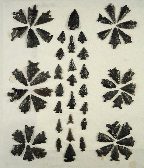 Nice selection of obsidian arrowheads found in Fort Rock, Oregon which are glued to a board.