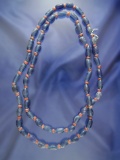 Strand of blue and red Catlinite trade beads that is approximately 35 inches long.