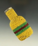 Very unique vintage cork top glass bottle adorned with cloth and beads from the late 1800s.