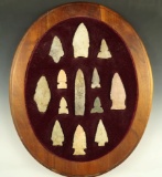 Set of 13 assorted arrowheads glued to a wood frame, largest is 3
