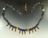 Beautiful strand of old trade beads and drilled canine teeth assembled into a necklace.