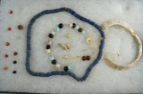 Assortment of glass and shell beads and ornaments from various locations.