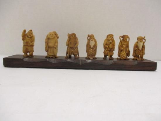 Seven Vintage Hand Carved Netsuke Figurines on Wood Plank