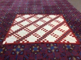 Handmade red and white diamond patterned quilt with blue accent