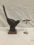 Bronze perching bird sculpture on a red marble/stone base