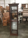 Vintage lighted three-shelf locking curio cabinet from an antique store