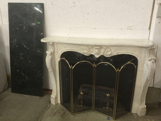 Decorative marble top electric fireplace with ornate mantle and brass screen