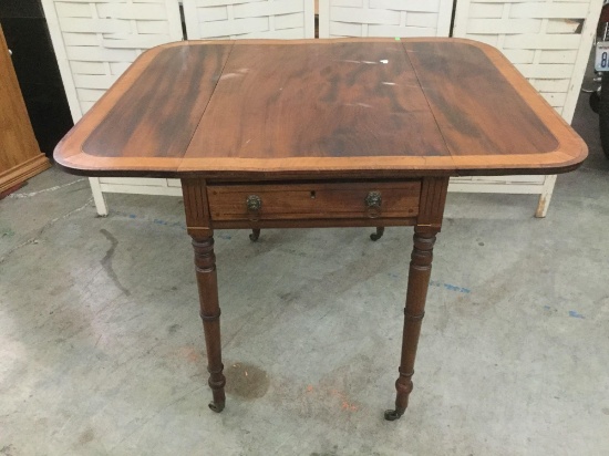 Antique drop leaf side table with drawer, lion head drawer pulls, and casters