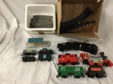 2x plastic toy train sets with engines, cars and track pieces.