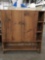 Antique wooden pantry storage with shelves and cupboard doors