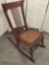Vintage stick back wooden rocking chair with wicker seat good cond