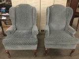 Pair of matching blue wingback arm chairs - missing on arm cover