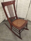Vintage stick back wooden rocking chair with wicker seat good cond