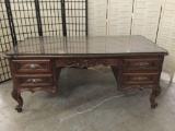 Large antique style mahogany executive desk with glass top and ornate design