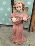 Painted cement garden statue of an angel playing the lute